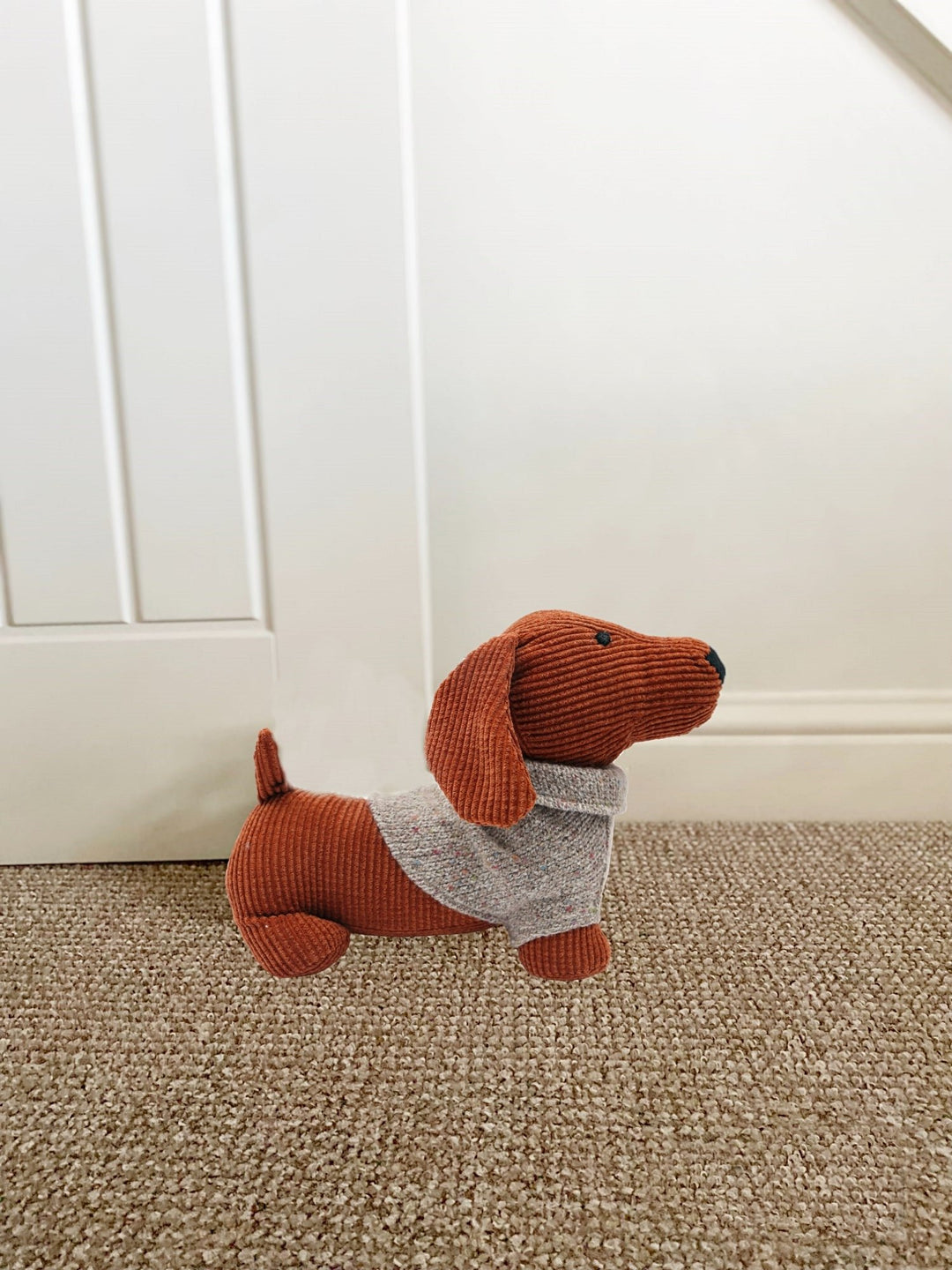 Adorable Orange Dog Doorstop with a Grey Jumper